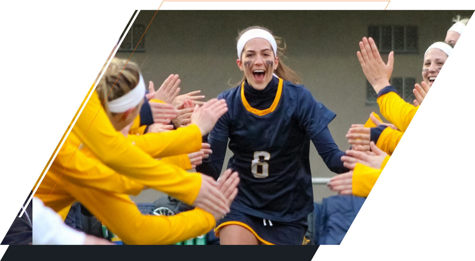 A female player celebrates with her team while smiling