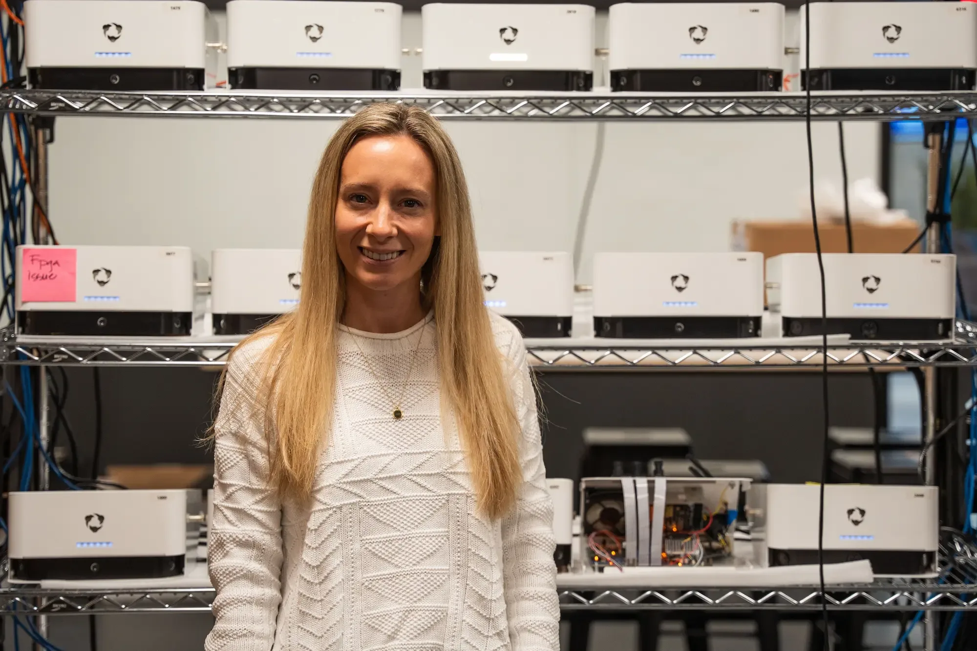 Photo of Michelle Henry standing in front of a shelf of Hudl Focus Indoor cameras.